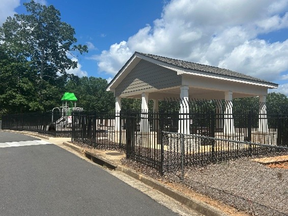 Shows the entrance and parking of a series of apartment buildings that contain parking stalls beneath them